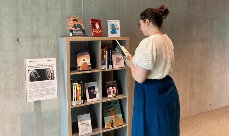 Bild unseres Bücherschau-Regals mit Nutzerin am Stöbern