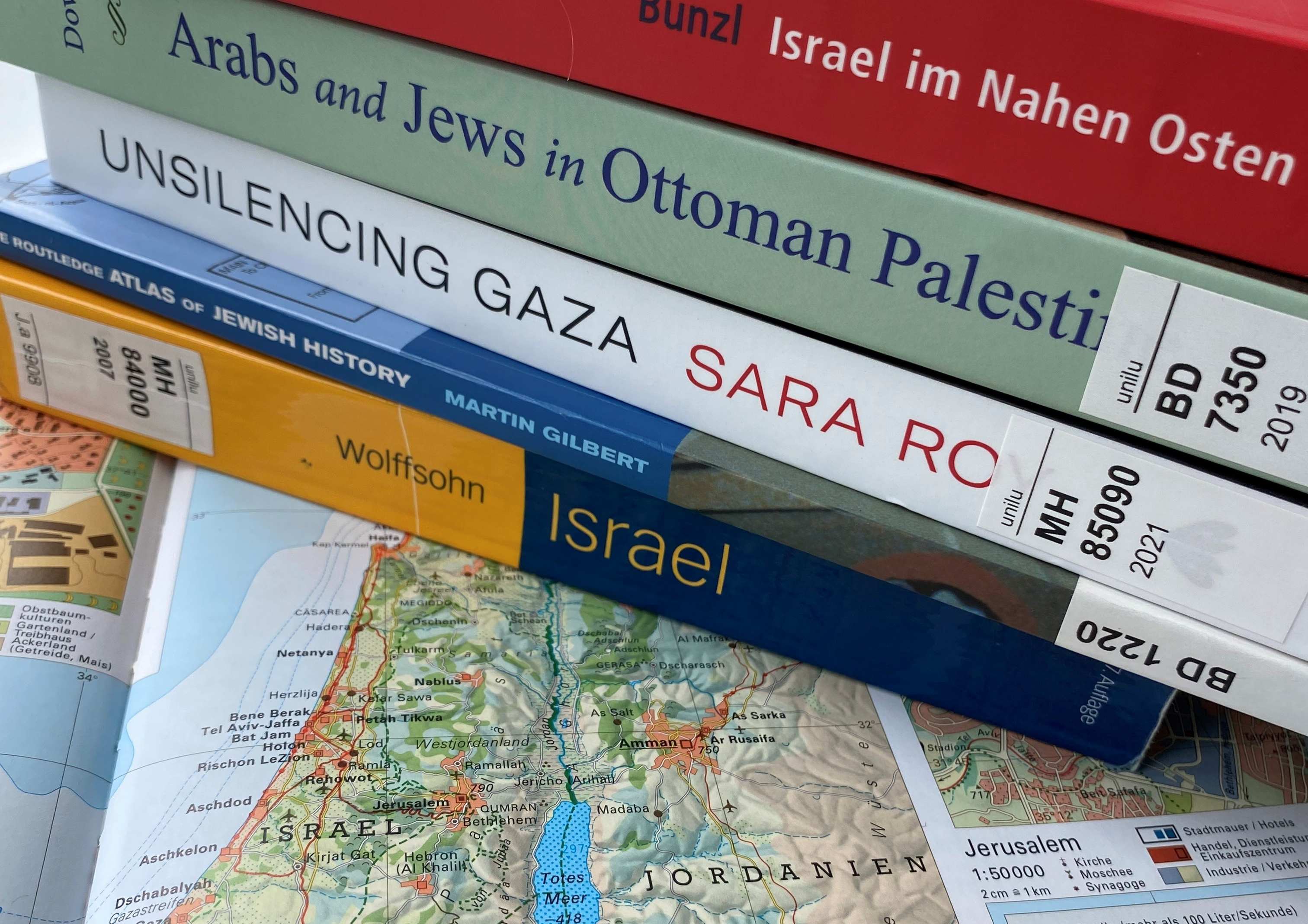 Illustration mit Abbildung einer Karte von Israel und Jordanien sowie diversen Büchern zum Thema aus dem Bibliotheksbestand der ZHHB